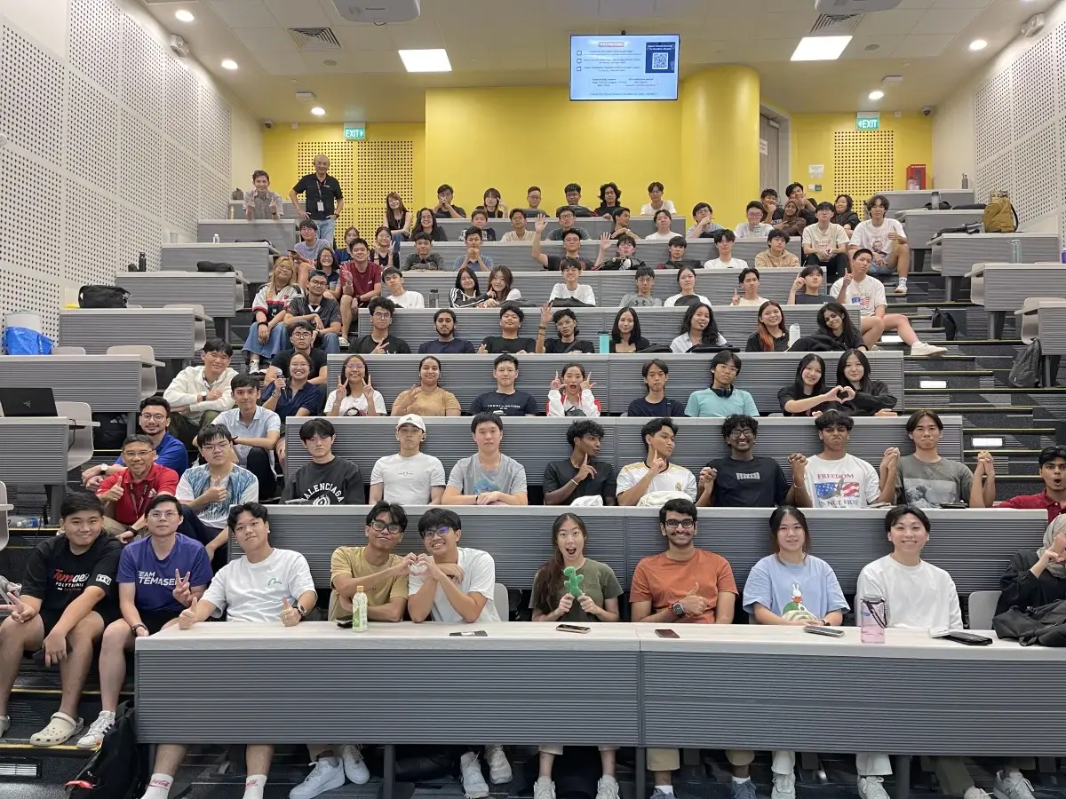 A large group of TP students seated together in a lecture hall, smiling and posing.