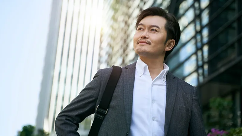 A confident middle-aged professional in Singapore, symbolizing the possibilities of midlife career change and upskilling through the SCTP initiative.